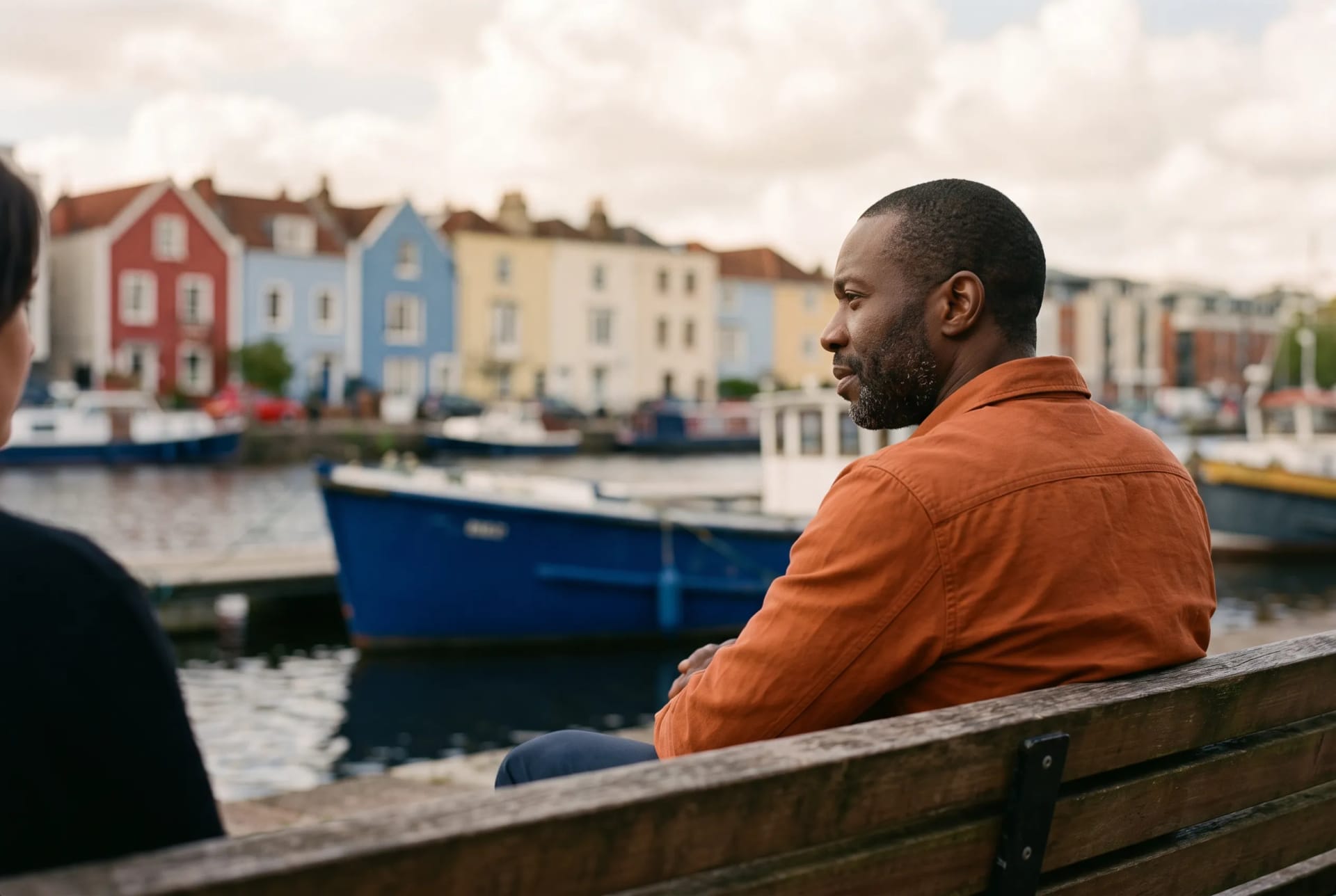 Marcus Grant in conversation on a harbourside bench in Bristol, no client identifiable